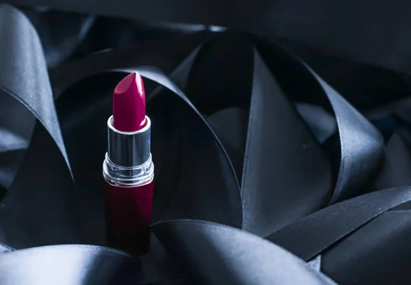 Lápiz labial púrpura sobre fondo de seda negro, maquillaje de lujo y cosméticos de belleza — Foto de Stock