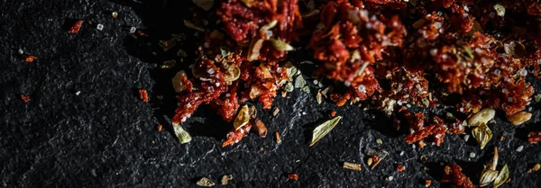 Gedroogde tomaat en chili peper close-up op luxe stenen achtergrond als platte lay, droog voedsel specerijen en recept ingrediënt — Stockfoto