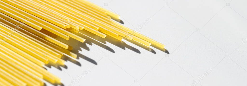 Uncooked whole grain spaghetti closeup, italian pasta as organic food ingredient, macro product and cook book recipe