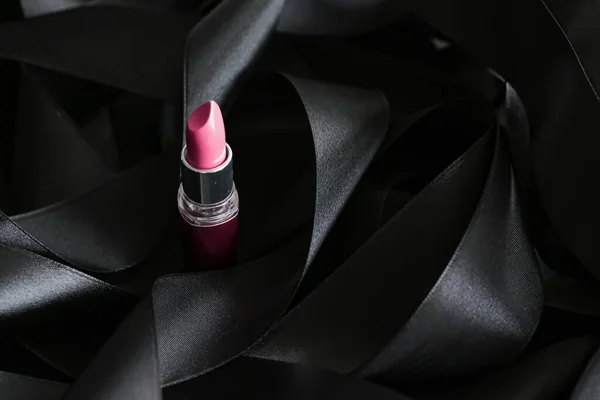 Batom rosa sobre fundo de seda preta, maquiagem de luxo e beleza cosmética — Fotografia de Stock