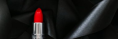 Siyah ipek arka planda kırmızı ruj, lüks makyaj ve güzellik kozmetik