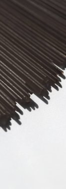 Çiğ çiğ spagetti, organik gıda malzemesi olarak İtalyan makarnası, makro ürün ve yemek kitabı tarifi.