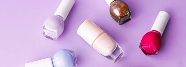 Лак для ногтей бутылки на фиолетовом фоне, бренд красоты — стоковое фото