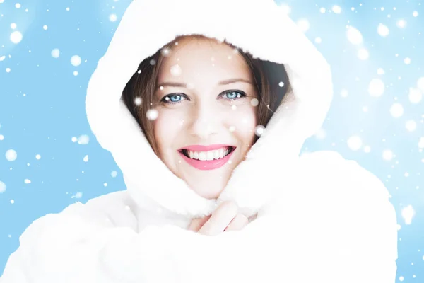 Retrato navideño e invernal de una joven con capucha blanca, nieve sobre fondo azul, moda y estilo de vida —  Fotos de Stock