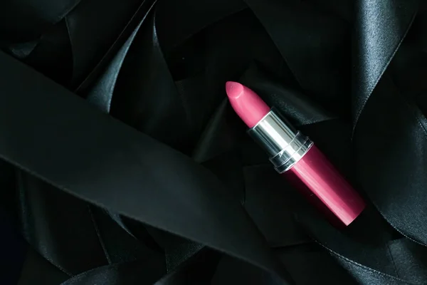 Lápiz labial rosa sobre fondo de seda negro, maquillaje de lujo y cosméticos de belleza — Foto de Stock