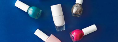 Koyu mavi arka planda oje şişeleri, güzellik markası.