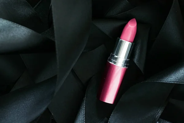 Lápiz labial rosa sobre fondo de seda negro, maquillaje de lujo y cosméticos de belleza — Foto de Stock