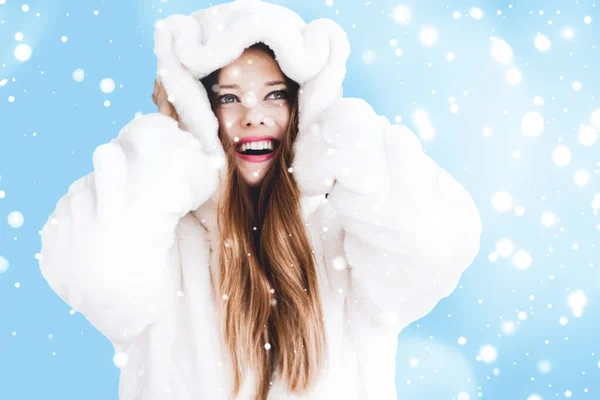 Natale e vacanza invernale ritratto di giovane donna in pelliccia bianca con cappuccio, neve su sfondo blu, moda e stile di vita — Foto Stock