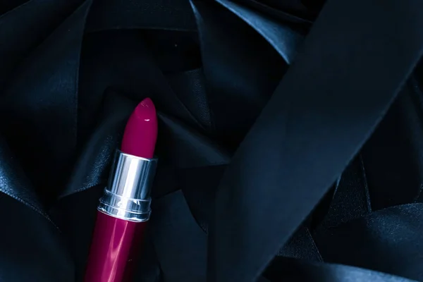 Фиолетовая помада на черном шелковом фоне, роскошный макияж и косметика красоты — стоковое фото