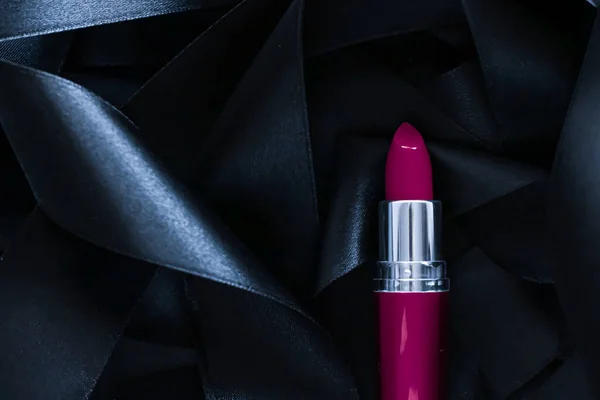 Lápiz labial púrpura sobre fondo de seda negro, maquillaje de lujo y cosméticos de belleza — Foto de Stock