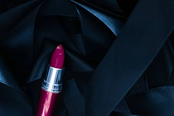Lápiz labial púrpura sobre fondo de seda negro, maquillaje de lujo y cosméticos de belleza — Foto de Stock