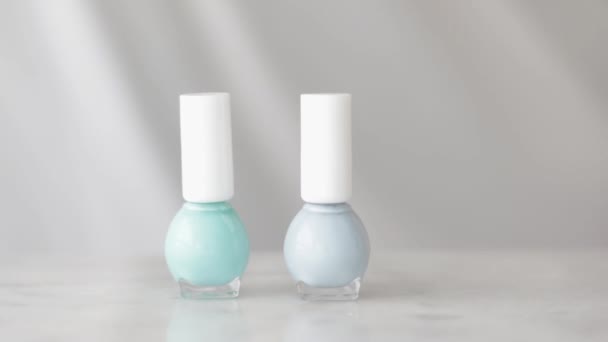 Cena de produto de beleza natural, mãos femininas e garrafas de esmalte para manicure francês, esmalte de unha pastel colorido na mesa de mármore, maquiagem e marca cosmética — Vídeo de Stock