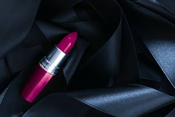 Lápiz labial púrpura sobre fondo de seda negro, maquillaje de lujo y cosméticos de belleza — Foto de Stock