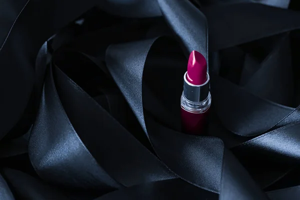 Lápiz labial púrpura sobre fondo de seda negro, maquillaje de lujo y cosméticos de belleza — Foto de Stock