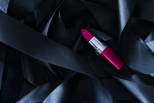 Lápiz labial púrpura sobre fondo de seda negro, maquillaje de lujo y cosméticos de belleza — Foto de Stock