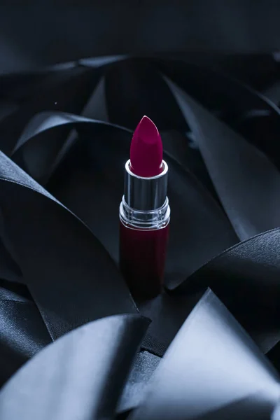 Lápiz labial púrpura sobre fondo de seda negro, maquillaje de lujo y cosméticos de belleza — Foto de Stock