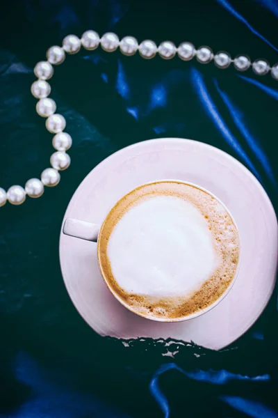 Cup of cappuccino for breakfast with satin and pearls jewellery background, organic coffee with lactose free milk in parisian cafe for luxury vintage holiday brand