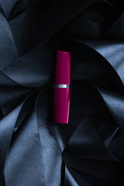 Lápiz labial púrpura sobre fondo de seda negro, maquillaje de lujo y cosméticos de belleza — Foto de Stock