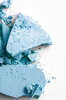 Makyaj paleti olarak mavi far pudrası beyaz arka planda izole edilmiş, ezilmiş kozmetik ve güzellik dokusu