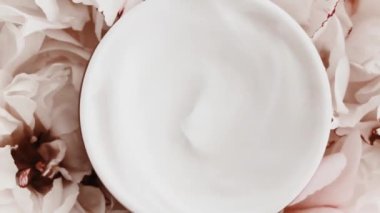 Yaşlanma önleyici yüz kremi kavanozu ve şakayık çiçekleri, lüks kozmetik ürünleri, güzellik ürünleri ve cilt ürünleri için cilt bakım rutini olarak temiz nemlendirici.