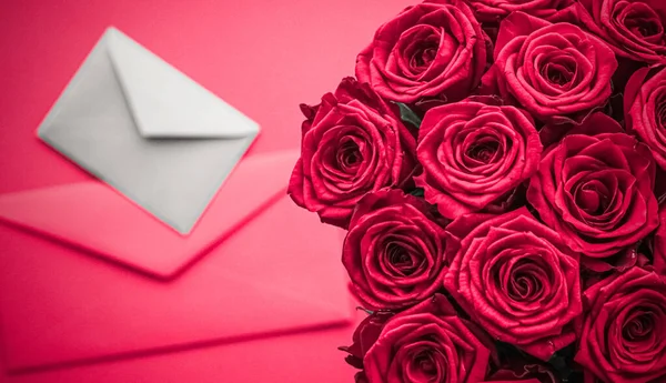 Παράδοση ερωτικών επιστολών και λουλουδιών την ημέρα του Αγίου Βαλεντίνου, πολυτελές μπουκέτο τριαντάφυλλα και κάρτα σε ροζ φόντο για ρομαντικό σχεδιασμό διακοπών — Φωτογραφία Αρχείου