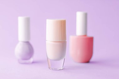 Mor arka planda oje şişeleri, güzellik markası.