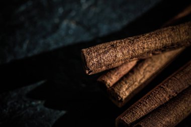 Tarçın çubukları siyah taş arka planda, yemek tarifi