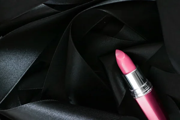 Batom rosa sobre fundo de seda preta, maquiagem de luxo e beleza cosmética — Fotografia de Stock