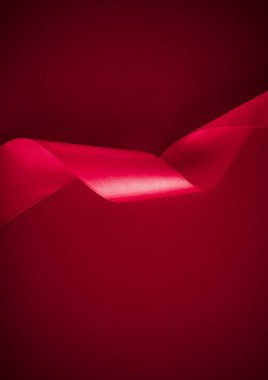 Pembe arka planda soyut kıvrımlı ipek kurdele, tatil ürünleri tanıtımı için özel lüks marka tasarımı ve cazibeli sanat davetiyesi arka planı.