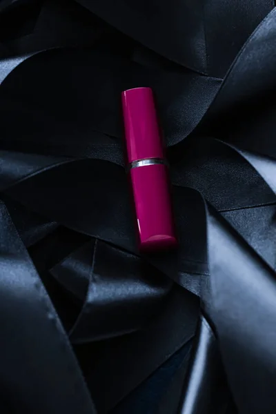 Lápiz labial púrpura sobre fondo de seda negro, maquillaje de lujo y cosméticos de belleza — Foto de Stock