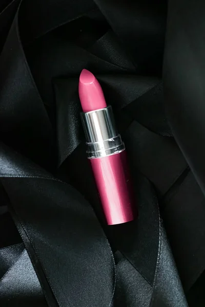 Lápiz labial rosa sobre fondo de seda negro, maquillaje de lujo y cosméticos de belleza — Foto de Stock