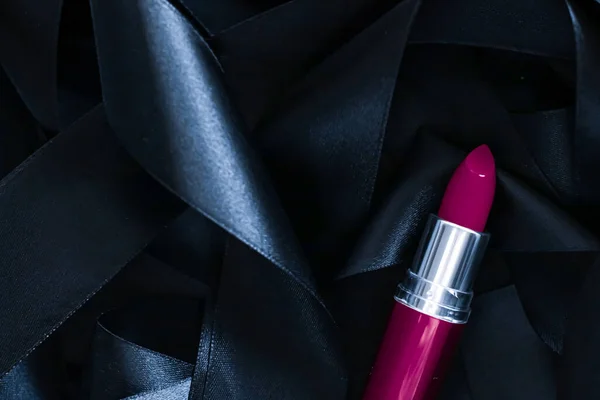 Lápiz labial púrpura sobre fondo de seda negro, maquillaje de lujo y cosméticos de belleza — Foto de Stock