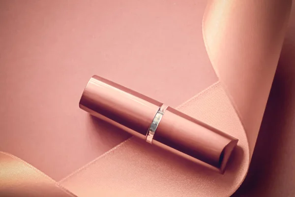 Lápiz labial de lujo y cinta de seda sobre fondo de fiesta rosa rubor, maquillaje y cosméticos flatlay para el diseño de productos de la marca de belleza — Foto de Stock