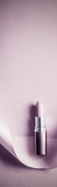 Роскошная помада и шелковая лента на розовом фиолетовом фоне праздника, макияж и косметика для дизайна бренда красоты — стоковое фото