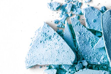 Makyaj paleti olarak mavi far pudrası beyaz arka planda izole edilmiş, ezilmiş kozmetik ve güzellik dokusu