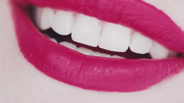 Dudakları pembe rujlu ve beyaz dişli gülümseyen, makro yakın plan mutlu kadın gülüşü, diş sağlığı ve güzellik makyajı — Stok video