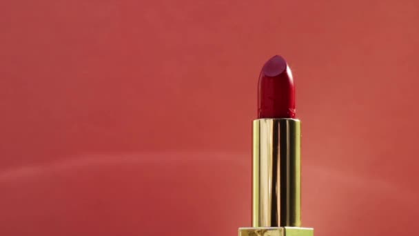 Batom vermelho chique em tubo dourado e clarões brilhantes, produto de maquiagem de luxo e cosméticos de férias para a marca de beleza — Vídeo de Stock