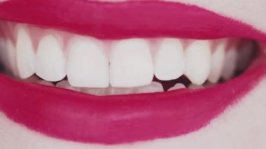 Dudakları pembe rujlu ve beyaz dişli gülümseyen, makro yakın plan mutlu kadın gülüşü, diş sağlığı ve güzellik makyajı