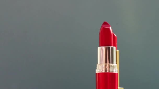 Batom vermelho de luxo em tubo dourado sobre fundo de cor e clarões brilhantes, produto de maquilhagem de luxo e cosméticos de férias para a marca de beleza — Vídeo de Stock