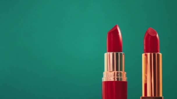 Dua lipstik merah chic pada latar belakang hijau dan suar cahaya bersinar, produk make-up mewah dan kosmetik liburan untuk merek kecantikan — Stok Video