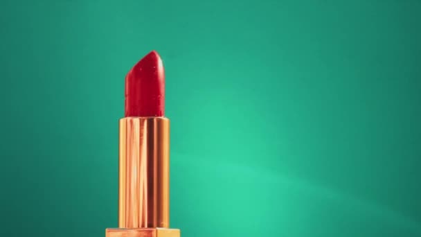 Rossetto rosso chic in tubo dorato su sfondo verde e brillanti brillanti brillamenti luminosi, prodotti per il trucco di lusso e cosmetici per le vacanze per il marchio di bellezza — Video Stock