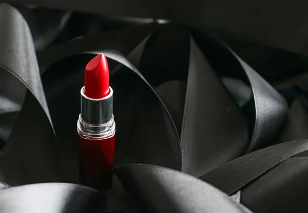 Red lipstick on black silk background, luxury make-up and beauty cosmetic