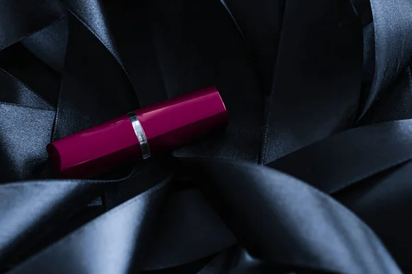 Lápiz labial púrpura sobre fondo de seda negro, maquillaje de lujo y cosméticos de belleza — Foto de Stock