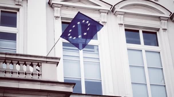 Bandera de la Unión Europea ondeando sobre un edificio en Bruselas, Bélgica, símbolo del Parlamento Europeo, la Comisión y el Consejo — Vídeo de stock