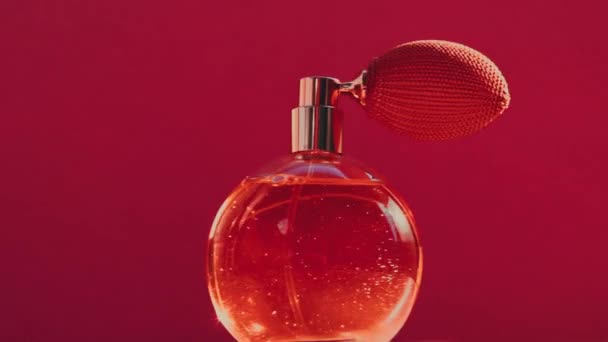 Vintage parfumflesje en stralende lichtfakkels op rode achtergrond, glamoureuze geur als luxe parfumerieproduct voor cosmetisch en beauty merk — Stockvideo