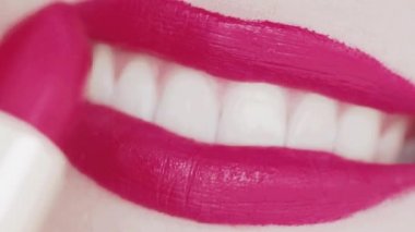 Dudakları pembe rujlu ve beyaz dişli gülümseyen, makro yakın plan mutlu kadın gülüşü, diş sağlığı ve güzellik makyajı