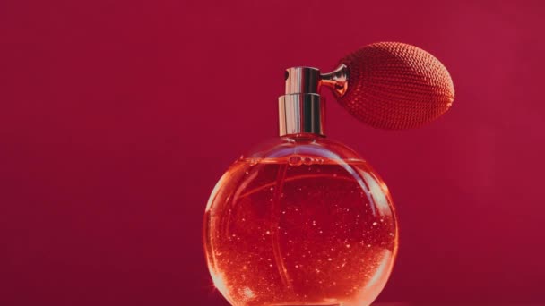 Flacon de parfum vintage et flambeaux lumineux sur fond rouge, parfum glamour comme produit de parfumerie de luxe pour la marque de cosmétiques et de beauté — Video