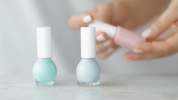 Natural beauty product scene, female hands and nailpolish bottles for french manicure, colourful pastel nail polish on marble table, make-up and cosmetic brand — Stock Video