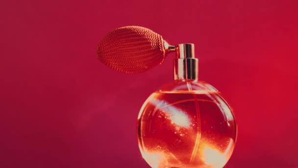 Винтажные духи бутылки и яркие световые вспышки на красном фоне, гламурный аромат как роскошный парфюмерный продукт для косметической и косметической марки — стоковое видео