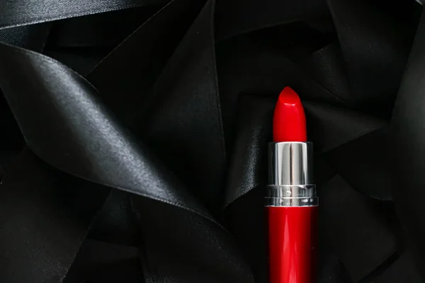 Lápiz labial rojo sobre fondo de seda negro, maquillaje de lujo y cosméticos de belleza — Foto de Stock